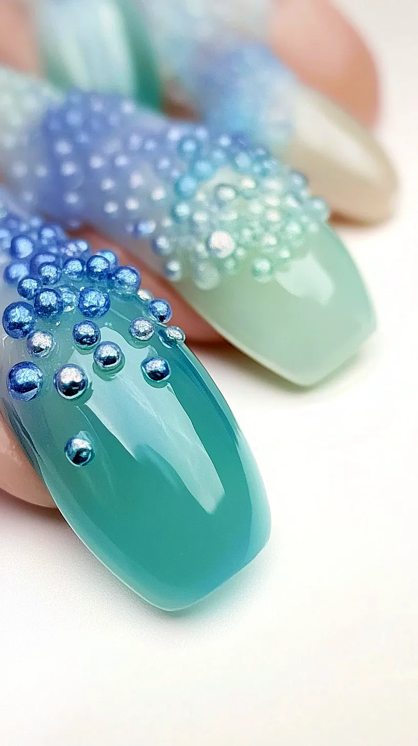 40+ Aesthetic Ocean Nails You Will Adore 11 Eye-catching nail art design featuring a cool blend of blue and green shades, embellished with 3D beads for added texture, transforming each nail into a tiny artistic canvas.