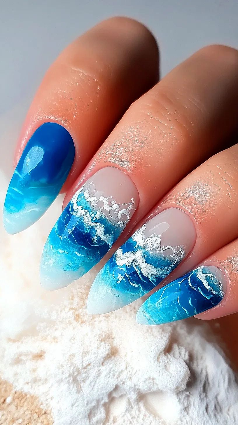 40+ Aesthetic Ocean Nails You Will Adore 7 Close-up image of ocean-themed nail art with intricate wave patterns in varying shades of blue and white on each fingernail, symbolizing a persons love for the sea and unique nail designs.